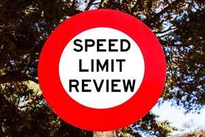 A speed limit sign with speed limit review wording