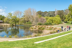 A family group walk around the lake at Bason Botanic Gardens