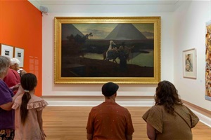 Image of two people sitting looking at a painting