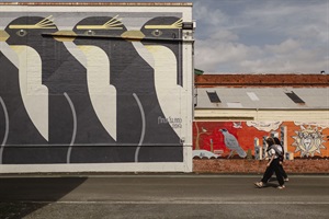 Two people viewing Whanganui street art with penguin mural in the foreground