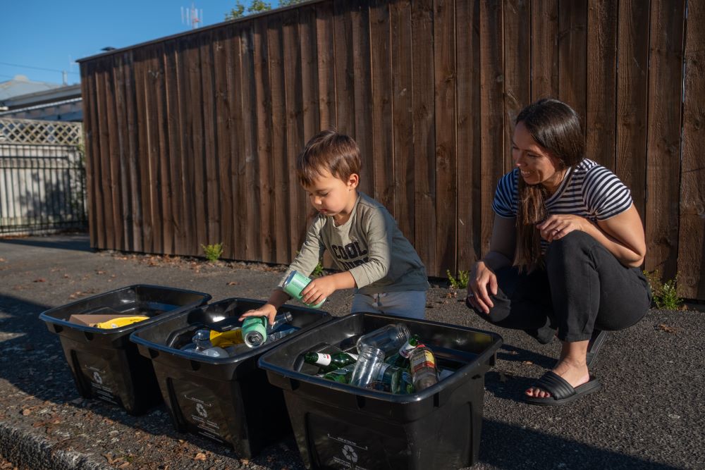 Image of a Whanganui resident and their kid putting their recycling crates out at the kerb