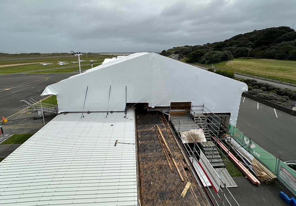 Side view of Whanganui Airport's terminal covered in a construction tent during its reroofing process